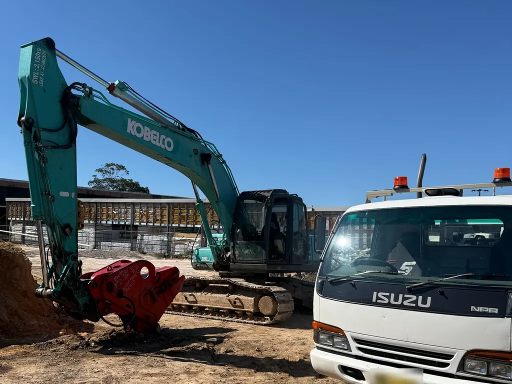 Nader Diesel Industries service truck parked beside a Kobelco excavator on a Sydney job site